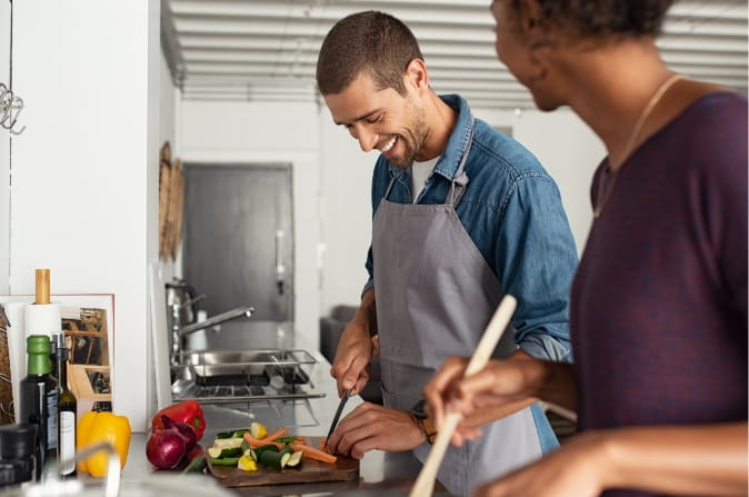 Young man and woman cook in kitchen